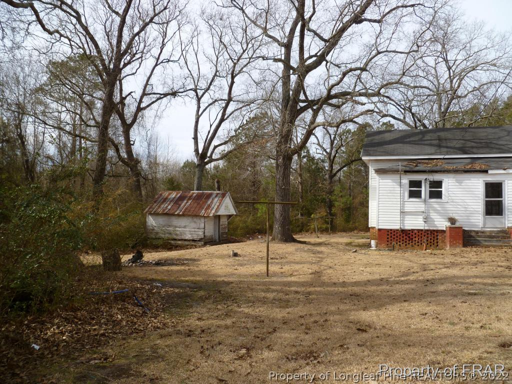2861 Turnpike Road Raeford, NC 28376 - Photo 5 of 22 a backyard of a house with large trees and covered with tall trees