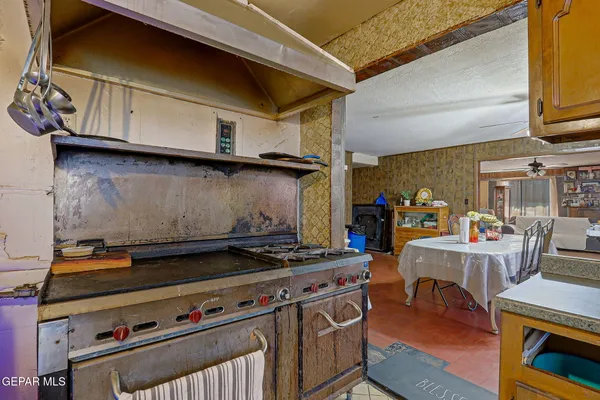 a kitchen with a stove and a wooden floor
