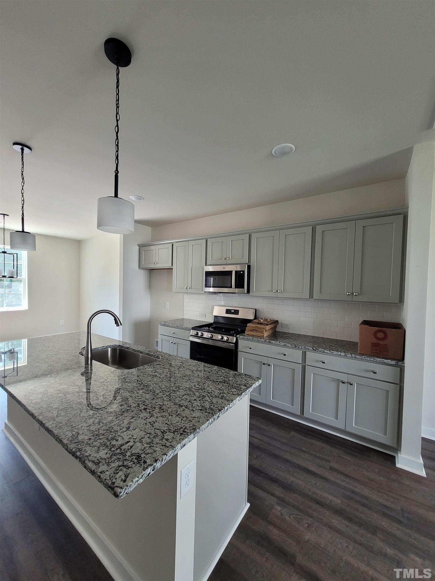 806 Laurel Gate Drive Wake Forest, NC 27587 - Photo 5 of 19 a kitchen with kitchen island granite countertop a sink cabinets and wooden floor