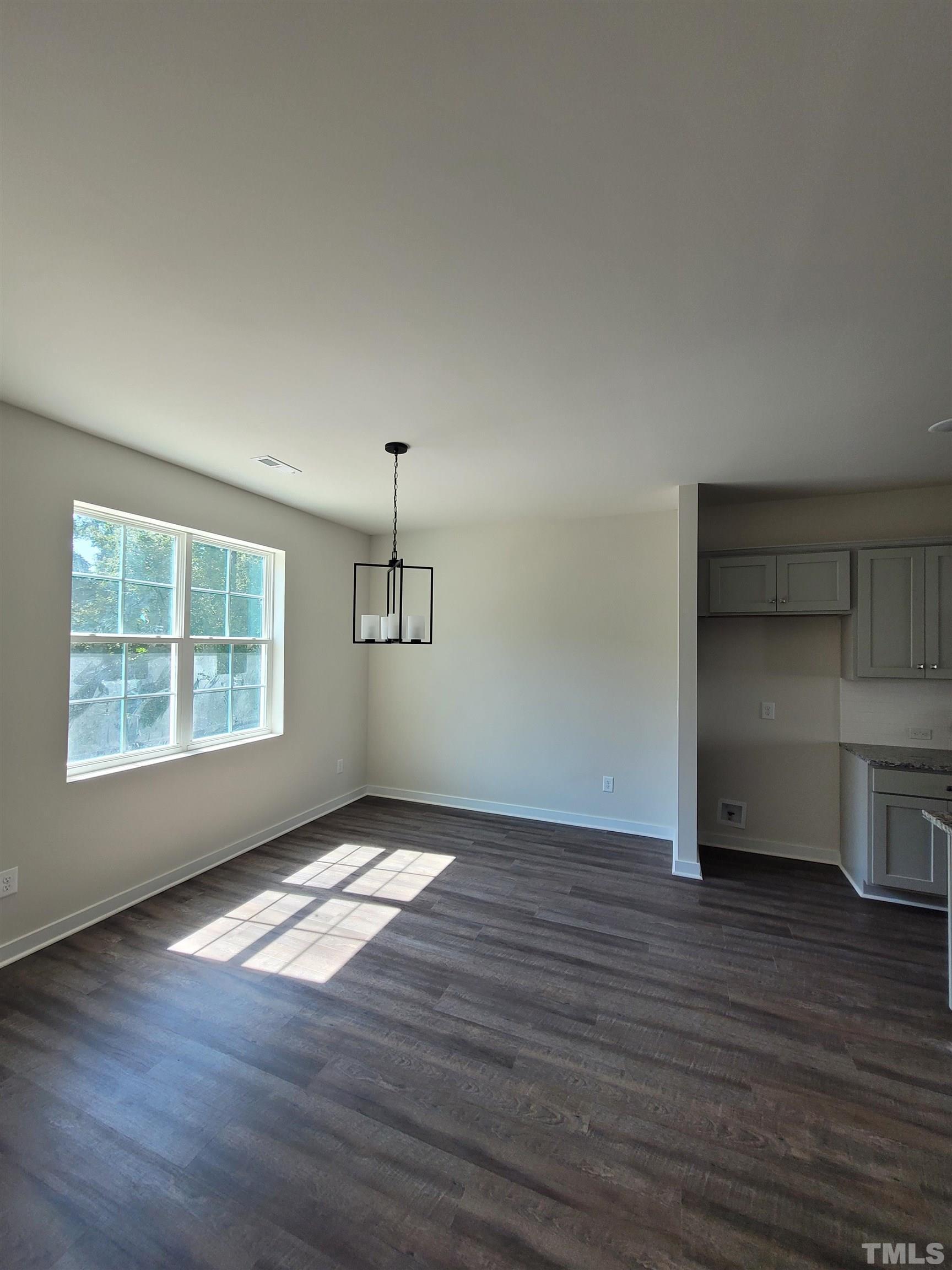 806 Laurel Gate Drive Wake Forest, NC 27587 - Photo 6 of 19 an empty room with wooden floor cabinet and windows