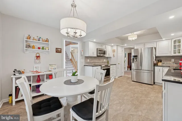 a kitchen with stainless steel appliances a table chairs and refrigerator
