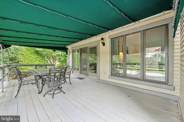 a patio with table and chairs and potted plants with wooden floor