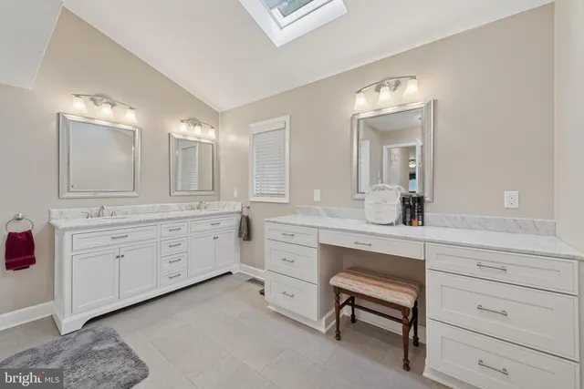 a spacious bathroom with a granite countertop sink and a mirror