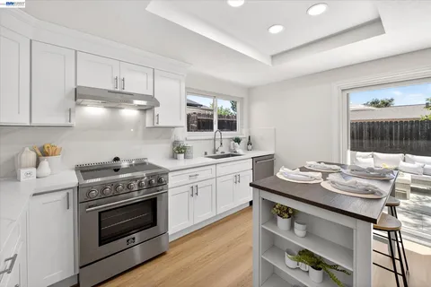 a kitchen with a stove cabinets and wooden floor