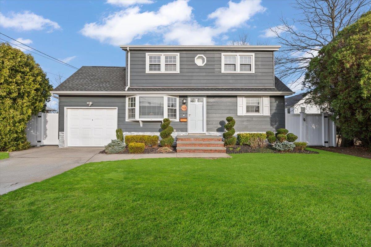 a front view of a house with a garden and yard