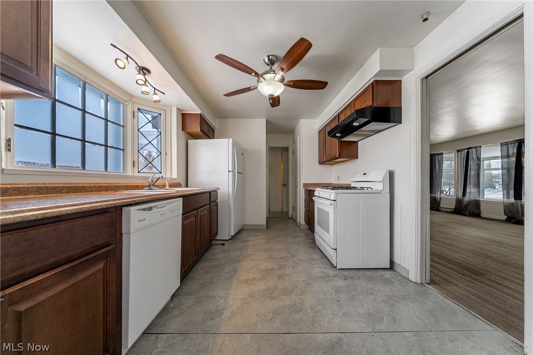 4602 College Road South Euclid, OH 44121 - Photo 6 of 26 Kitchen with white appliances, extractor fan, ceiling fan, and dark wood finish cabinets
