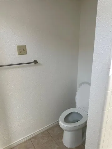 a white toilet sitting next to a white wall