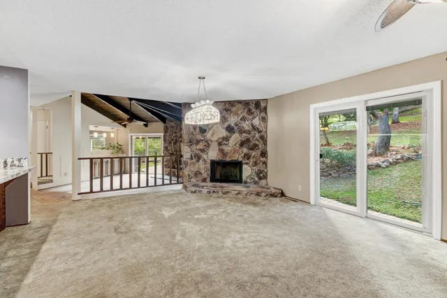 a view of an empty room with a fireplace and a window