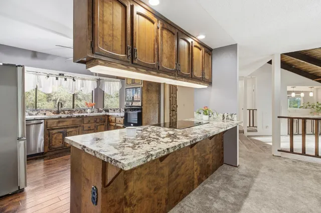 a kitchen with stainless steel appliances granite countertop a sink and cabinets