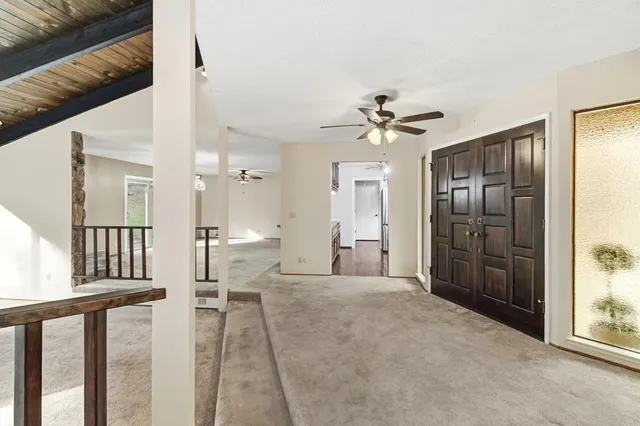 a living room with furniture a ceiling fan and a window