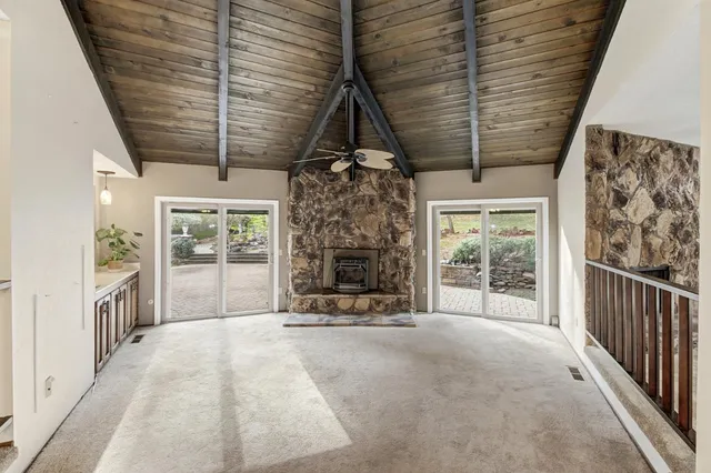 a view of an empty room with a fireplace and a window