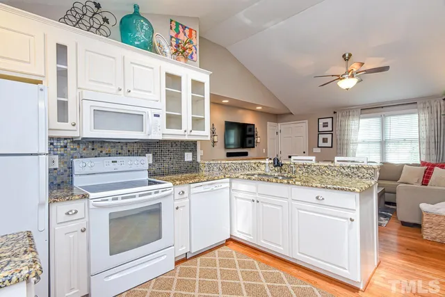 a kitchen with stainless steel appliances granite countertop a stove sink and cabinets