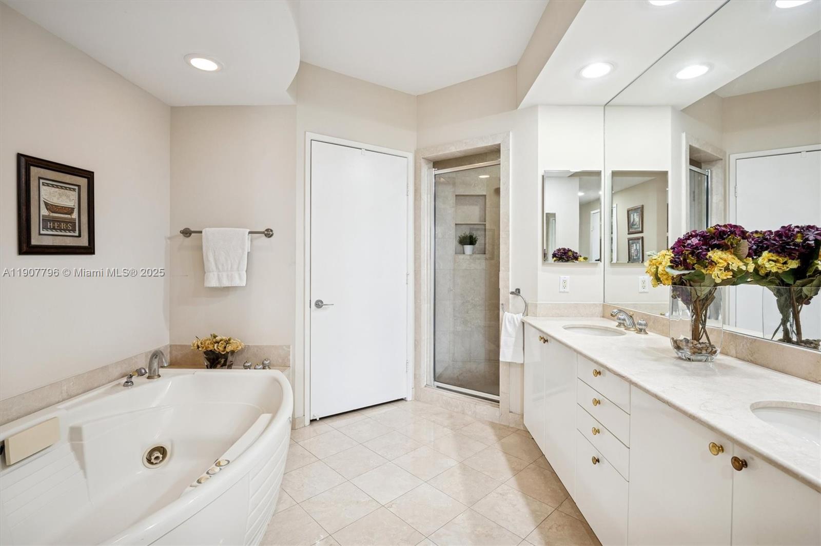 789 Crandon Boulevard, Unit 1005 Key Biscayne, FL 33149 - Photo 16 of 60 a bathroom with a tub sink and mirror