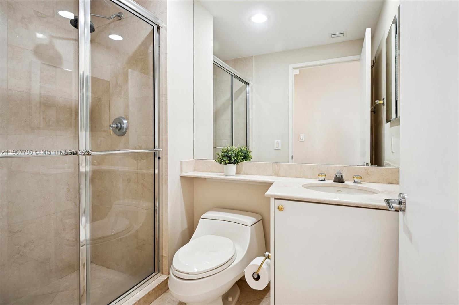 789 Crandon Boulevard, Unit 1005 Key Biscayne, FL 33149 - Photo 18 of 60 a bathroom with a granite countertop sink toilet and shower