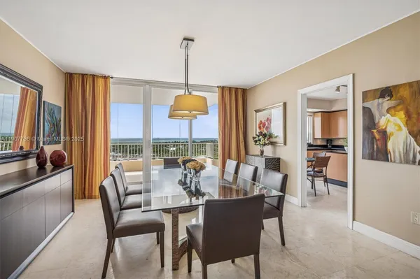 a dining room with furniture a chandelier and window