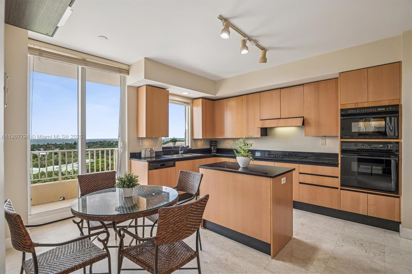 789 Crandon Boulevard, Unit 1005 Key Biscayne, FL 33149 - Photo 8 of 60 a kitchen with kitchen island a large counter top space and stainless steel appliances