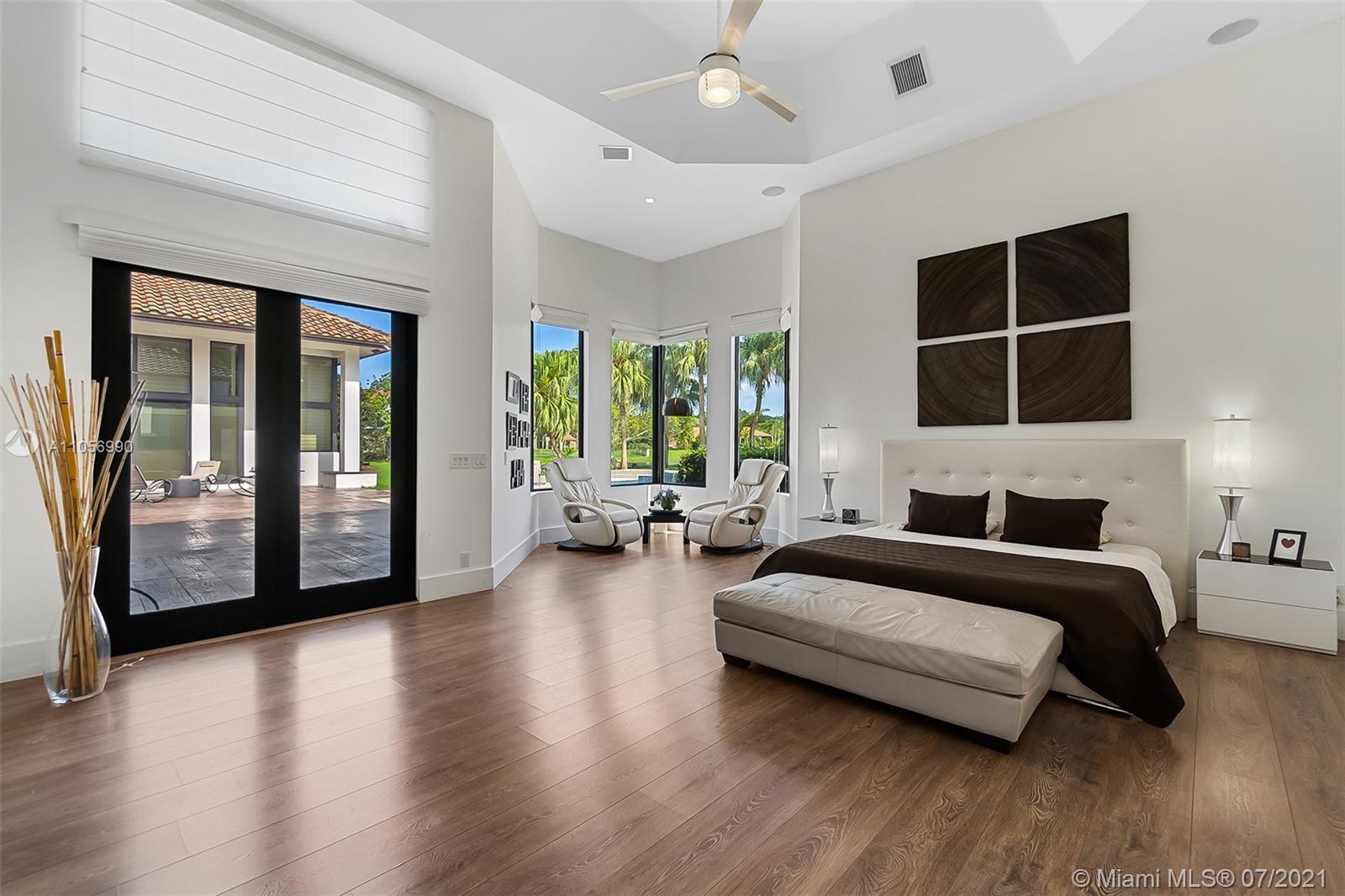 2850 Windmill Ranch Road Weston, FL 33331 - Photo 21 of 50 a spacious bedroom with a balcony a bed and glass walk in closet