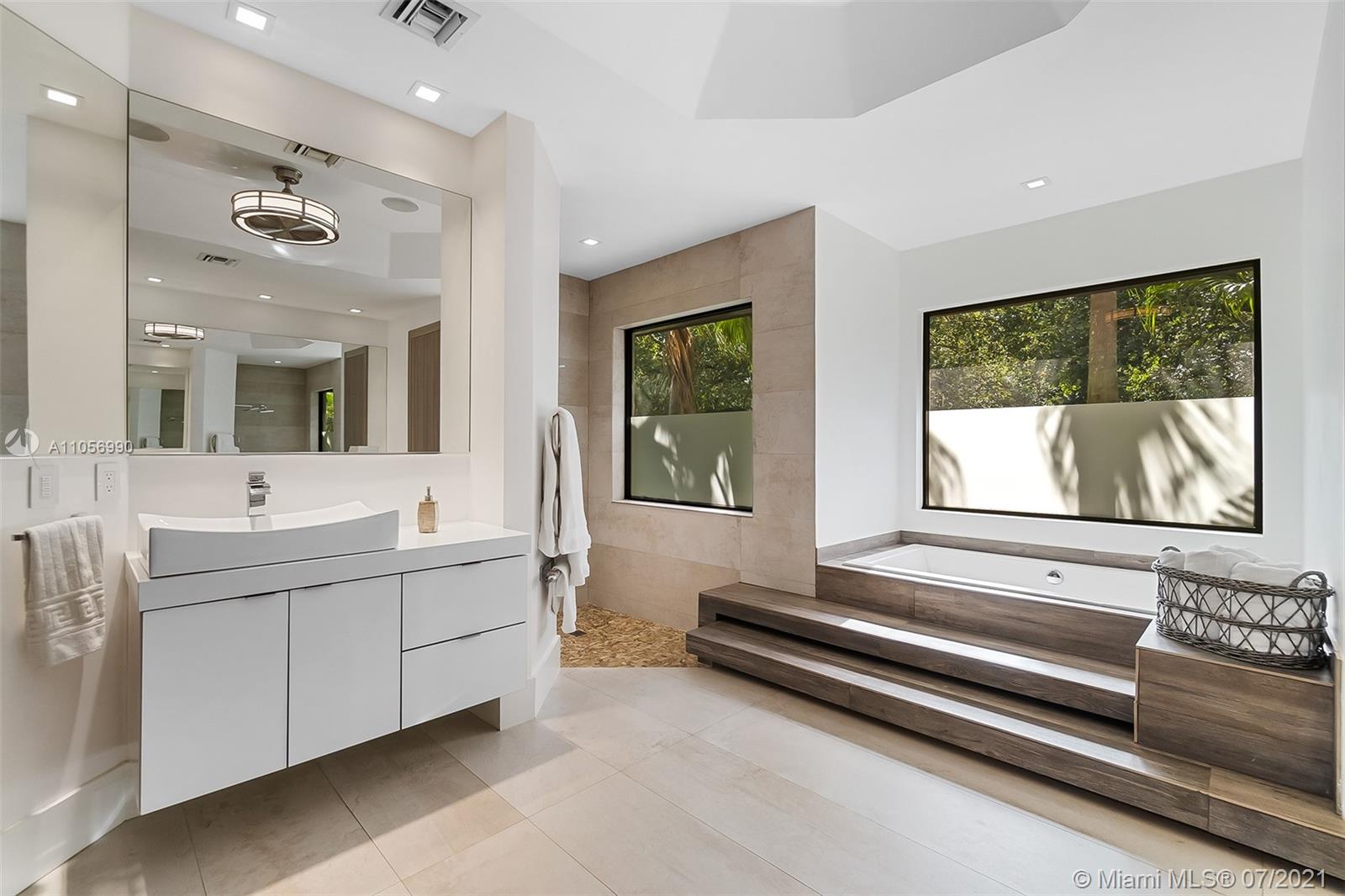2850 Windmill Ranch Road Weston, FL 33331 - Photo 24 of 50 a bathroom with a sink a large mirror and a bathtub next to a window