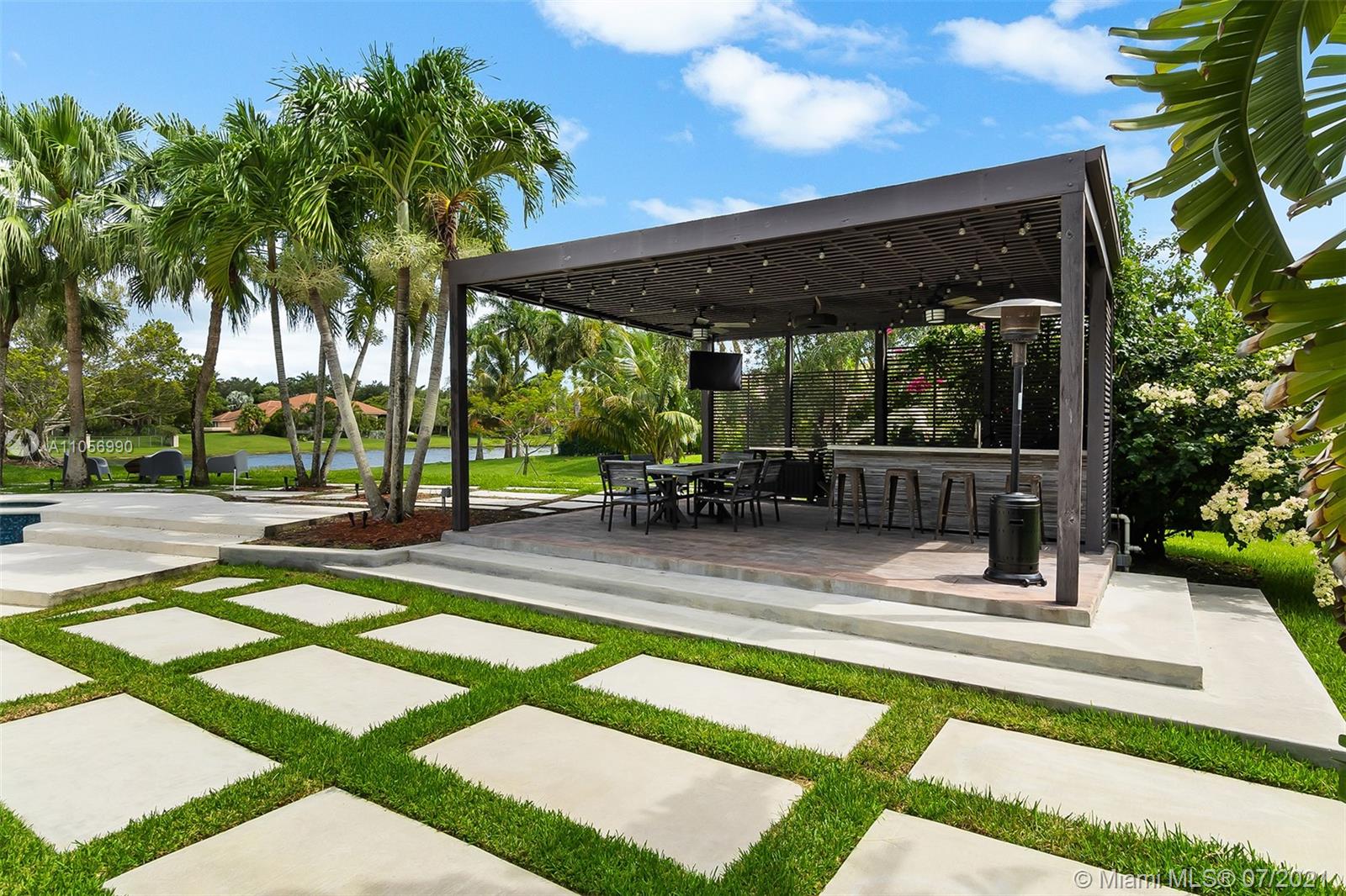 2850 Windmill Ranch Road Weston, FL 33331 - Photo 45 of 50 a view of a patio with table and chairs potted plants and palm tree