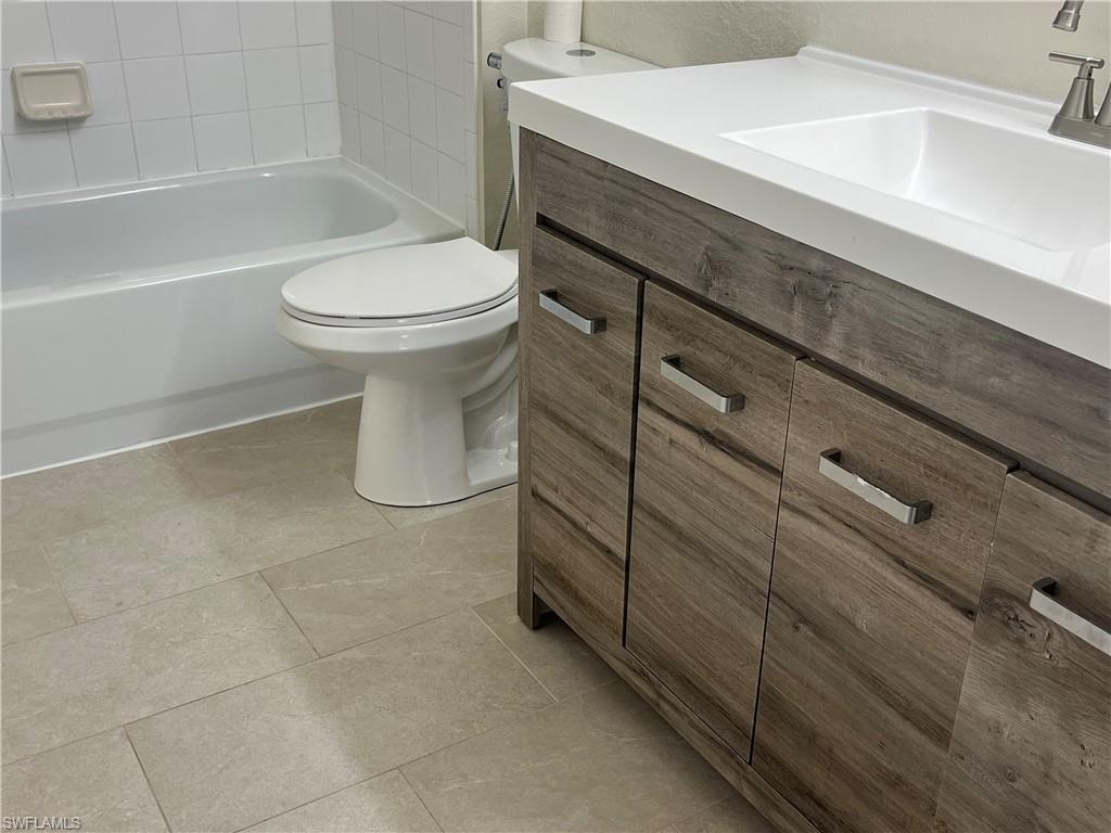 8224 Key Royal Circle, Unit 211 Naples, FL 34119 - Photo 13 of 25 a bathroom with a sink a toilet and bathtub