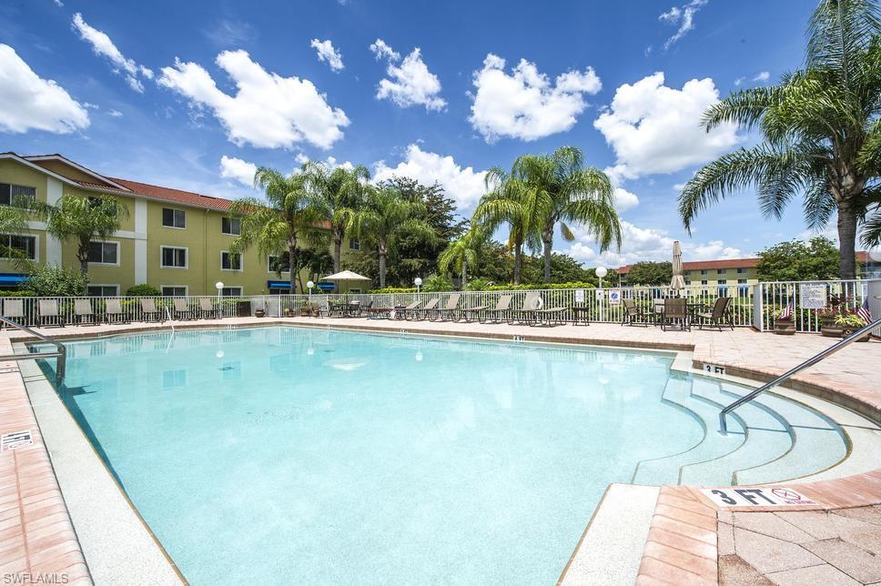 8224 Key Royal Circle, Unit 211 Naples, FL 34119 - Photo 17 of 25 a swimming pool with outdoor seating and yard