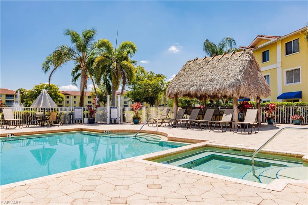 8224 Key Royal Circle, Unit 211 Naples, FL 34119 - Photo 19 of 25 a swimming pool with outdoor seating and yard