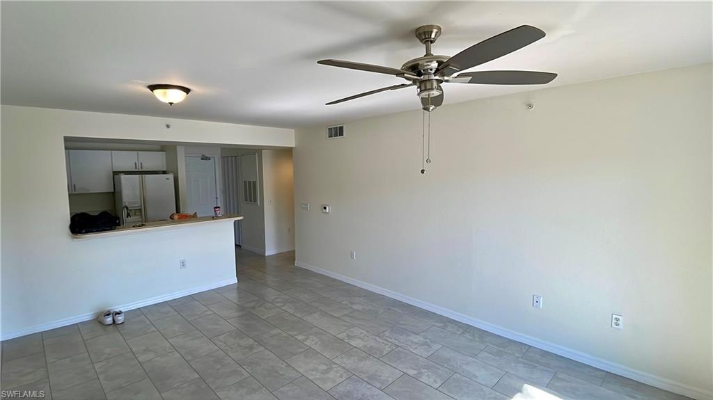 8224 Key Royal Circle, Unit 211 Naples, FL 34119 - Photo 6 of 25 a view of an empty room with window and a kitchen