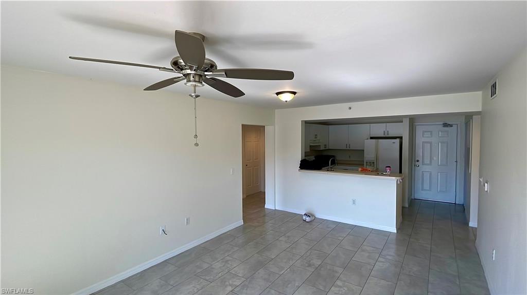 8224 Key Royal Circle, Unit 211 Naples, FL 34119 - Photo 7 of 25 a view of empty room with a ceiling fan