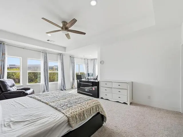 a bedroom with a bed and a large window