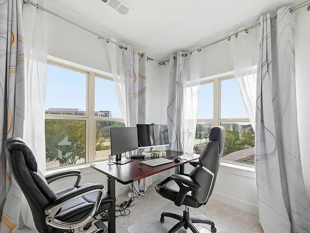 a view of a workspace with furniture and a window