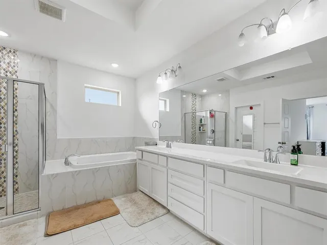 a bathroom with a tub a sink shower and mirror