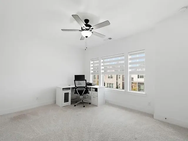 a view of a workspace with furniture and a window