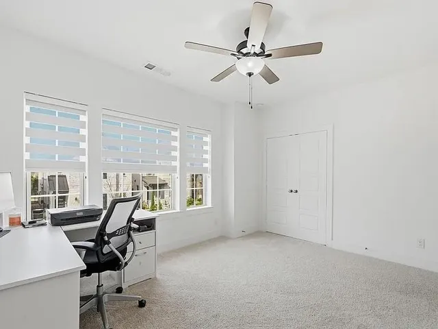 a view of a workspace with furniture and a window