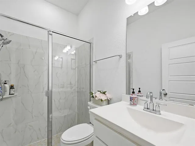 a bathroom with a sink a toilet and shower