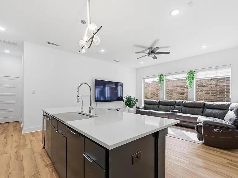 6844 Verandah Way Irving, TX 75039 - Photo 6 of 24 a kitchen with a stove a sink a kitchen island with wooden cabinets and couch
