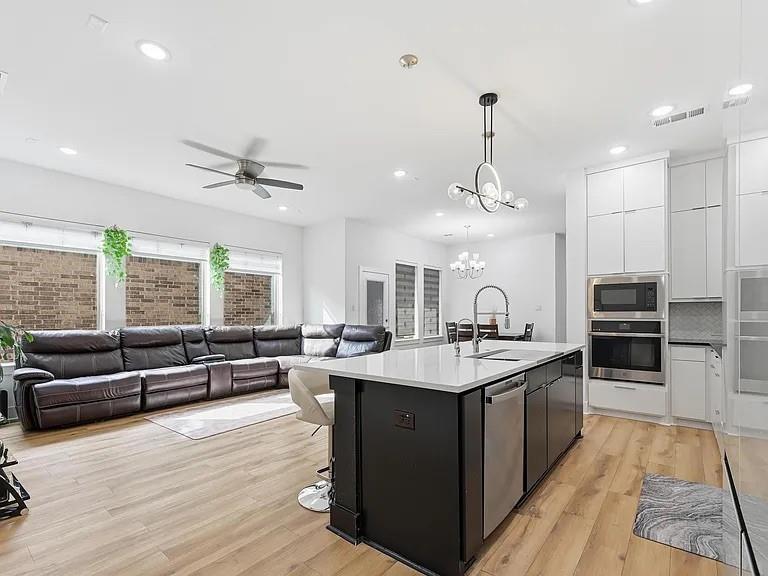 6844 Verandah Way Irving, TX 75039 - Photo 8 of 24 a open kitchen with stainless steel appliances granite countertop a sink dishwasher a stove and a dining table with wooden floor