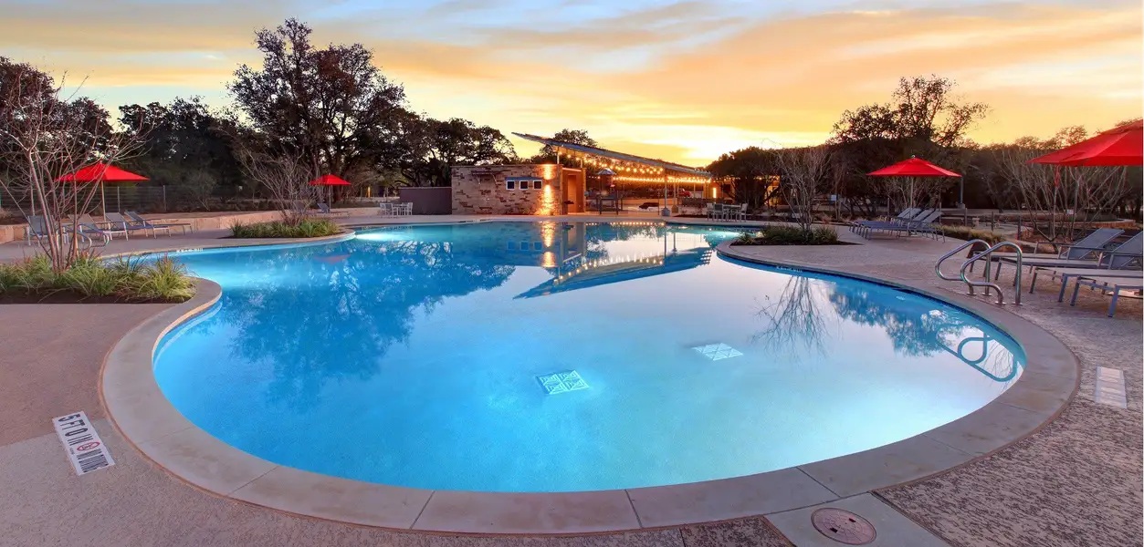 1908 Woolsey Way Leander, TX 78641 - Photo 32 of 36 Twilight casts an amber glow over this resort-style community pool, complete with a charming clubhouse.