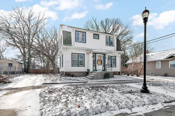 a front view of a house with a yard covered in snow