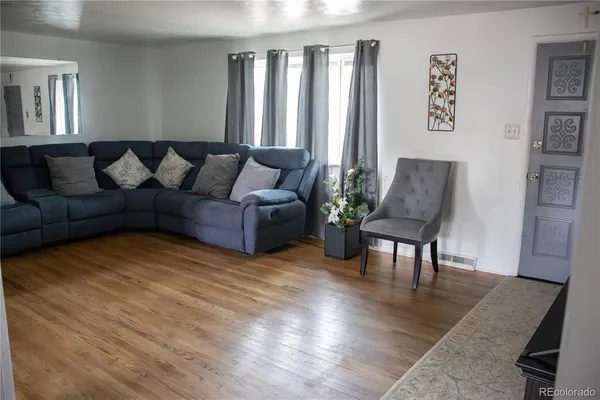 a living room with furniture and wooden floor
