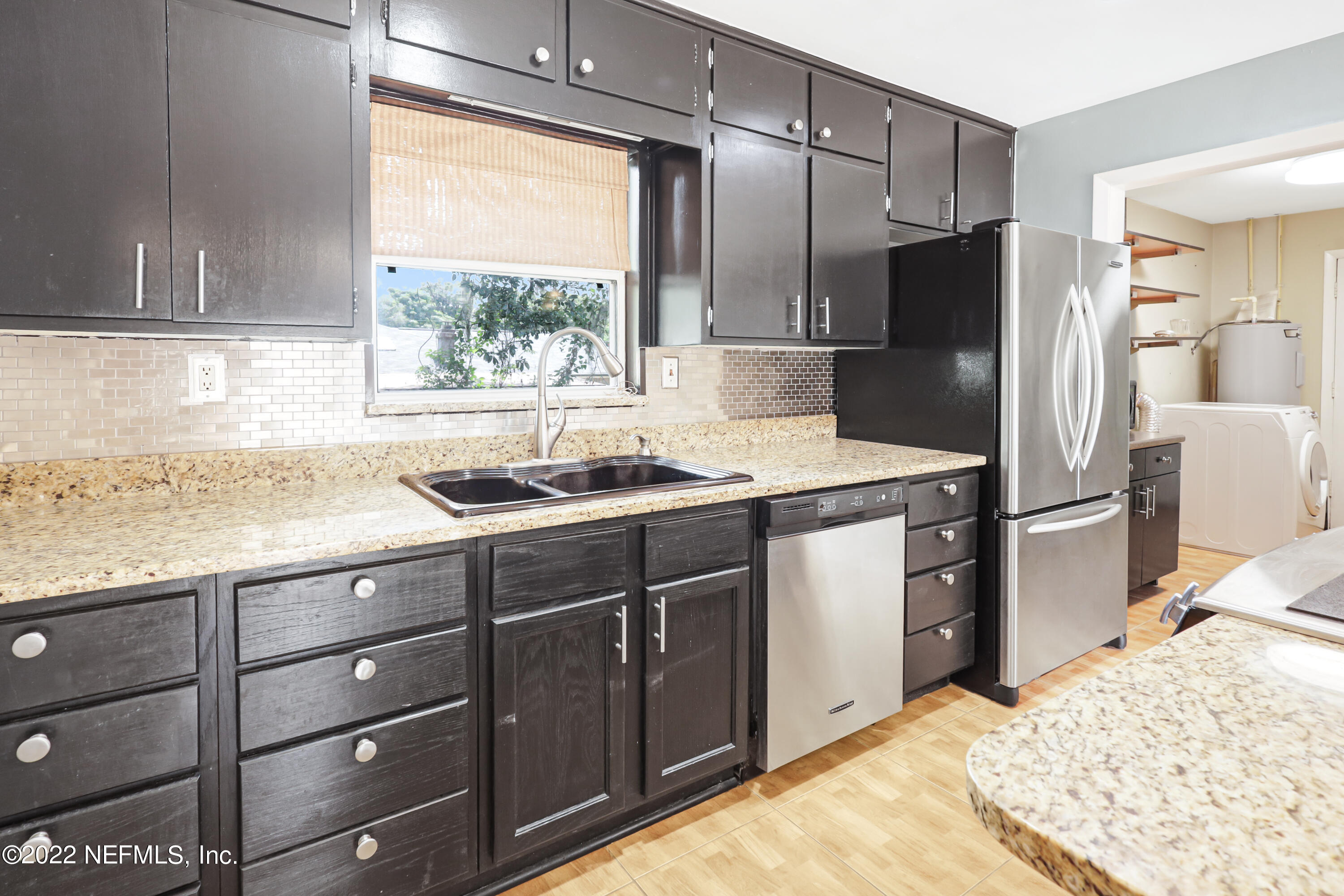3955 Heidi Road Jacksonville, FL 32277 - Photo 13 of 43 a kitchen with a refrigerator sink and cabinets