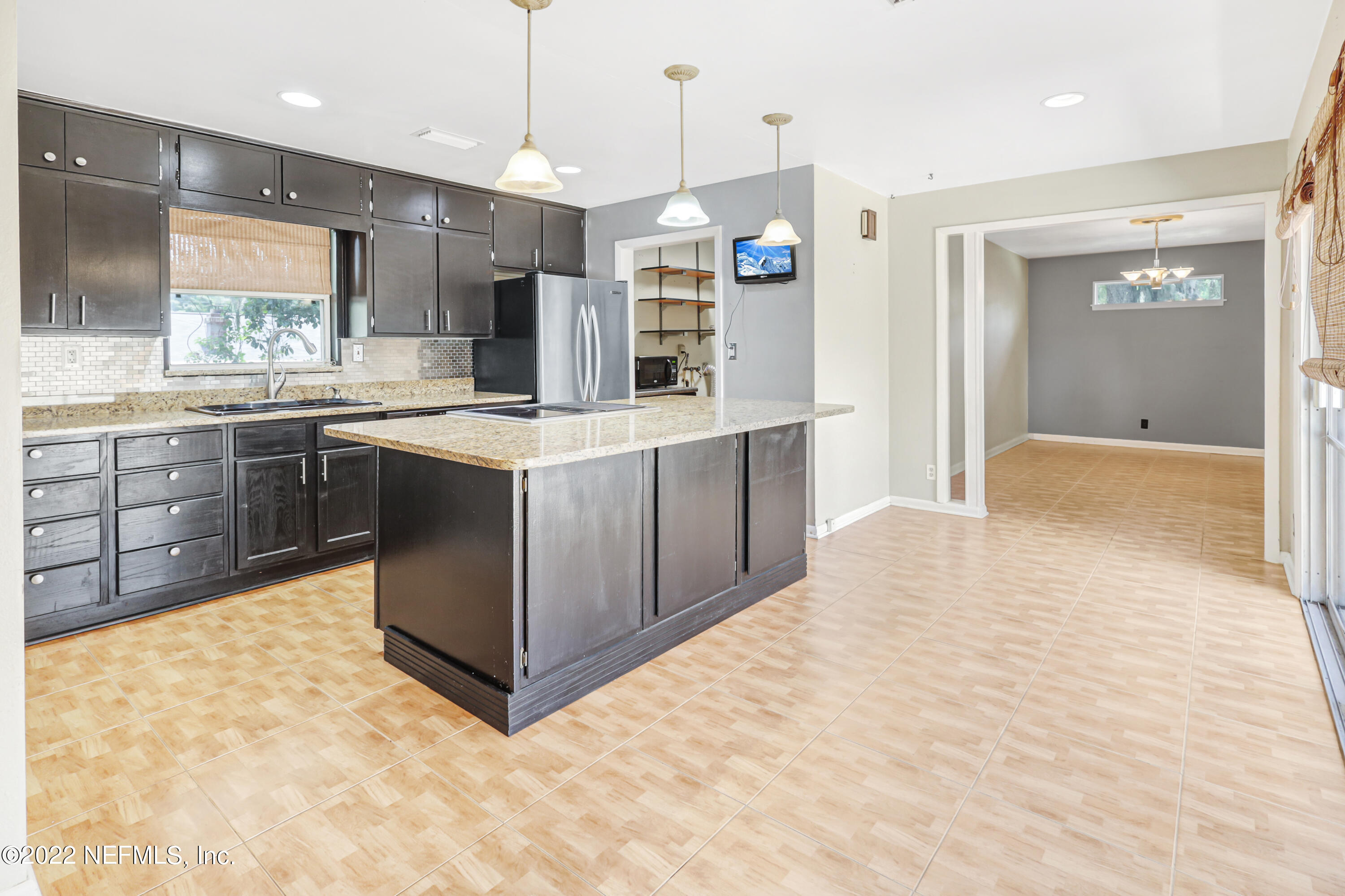 3955 Heidi Road Jacksonville, FL 32277 - Photo 14 of 43 a large kitchen with kitchen island a sink stainless steel appliances and cabinets