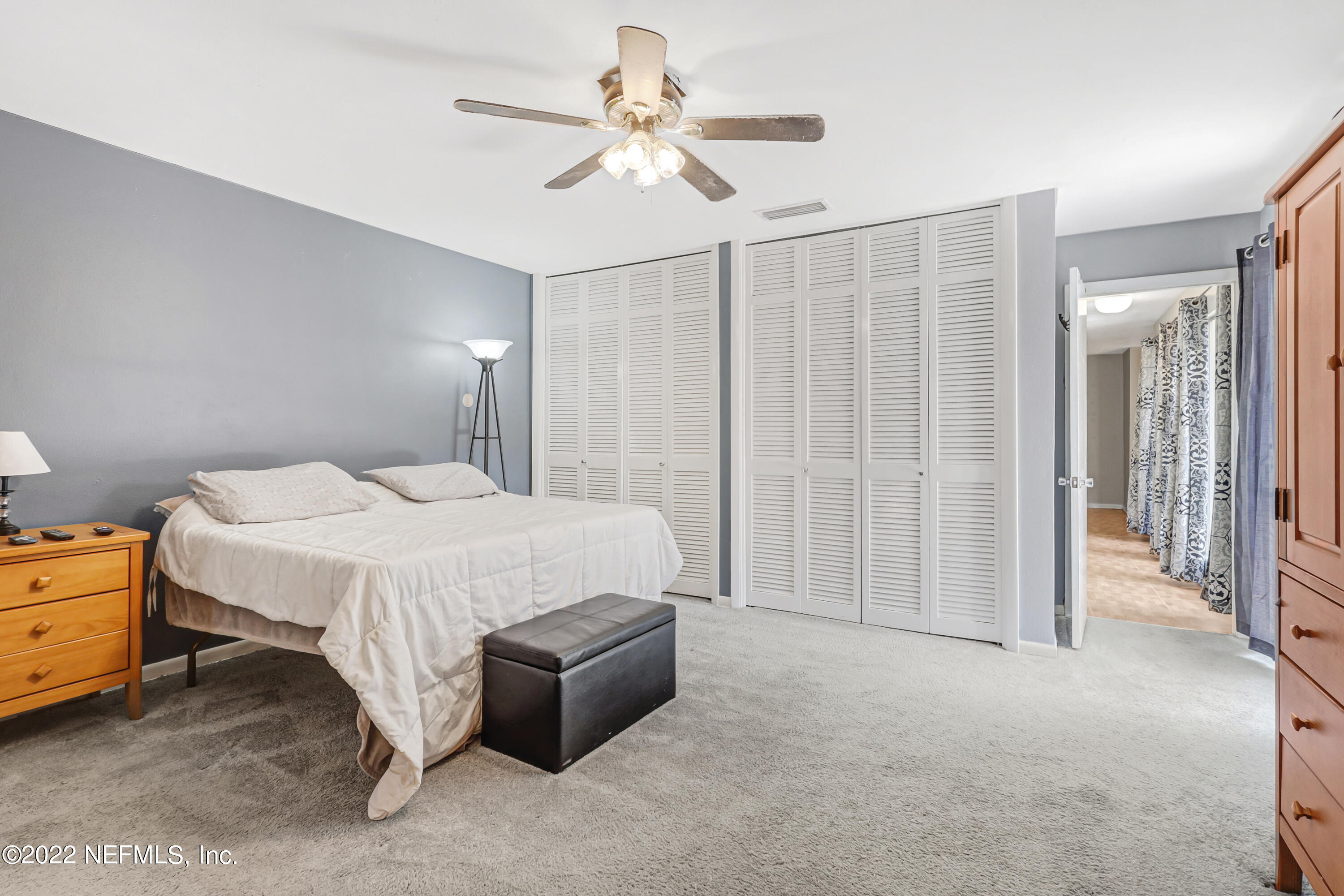 3955 Heidi Road Jacksonville, FL 32277 - Photo 30 of 43 a spacious bedroom with a bed and a chandelier
