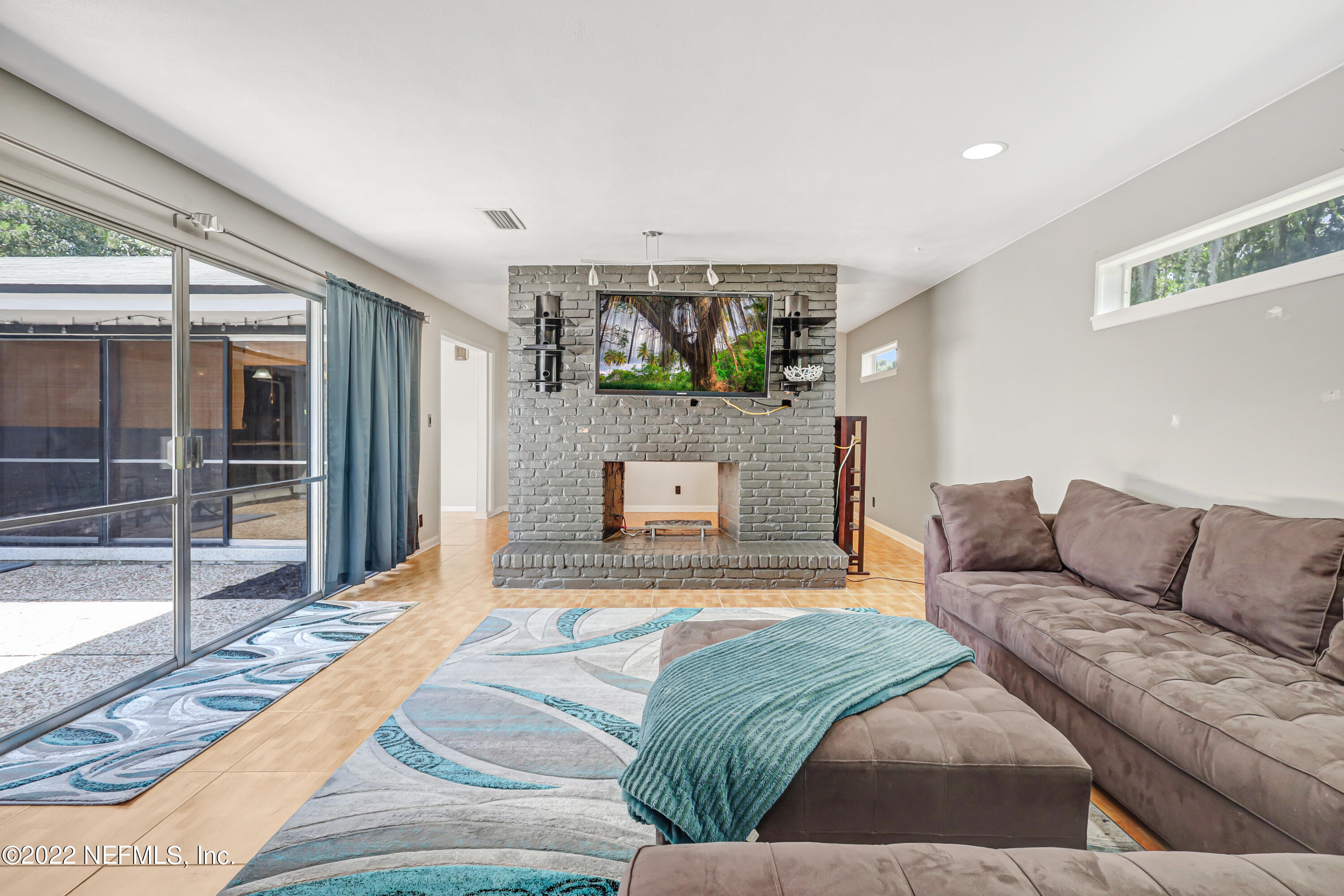 3955 Heidi Road Jacksonville, FL 32277 - Photo 8 of 43 a living room with a couch and a floor to ceiling window