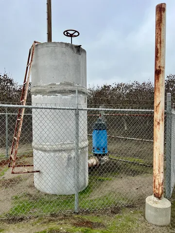 a view of a dry yard with wooden fence