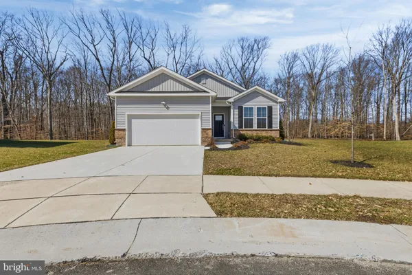 a front view of a house with a yard and trees