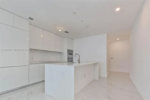 a kitchen with kitchen island cabinets and oven