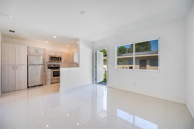 a view of kitchen with refrigerator and more cabinets