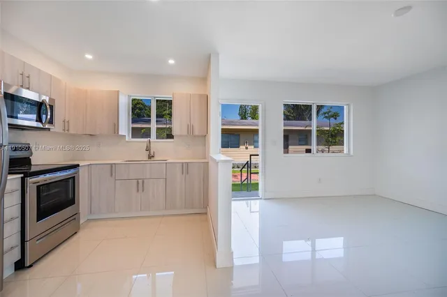 a kitchen with stainless steel appliances a stove a microwave and white cabinets