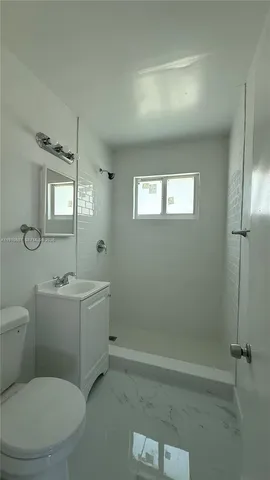 a bathroom with a toilet a sink and shower