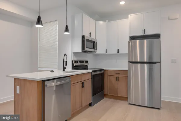 a kitchen with kitchen island a sink stainless steel appliances and cabinets